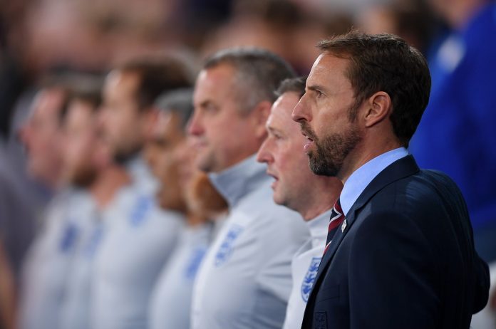 Gareth Southgate of England sings the National Anthem with his coaching staff ahead of the International Friendly match