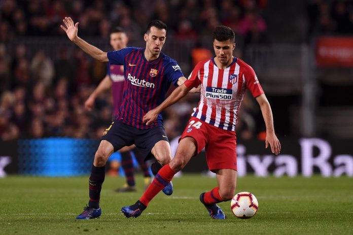 Rodri of Atletico Madrid evades Sergio Busquets of Barcelona during the La Liga match between FC Barcelona and Club Atletico de Madrid