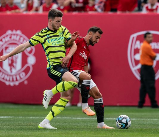 Arsenal midfielder Declan Rice and Manchester United captain Bruno Fernandes fight for the ball during an friendly game.