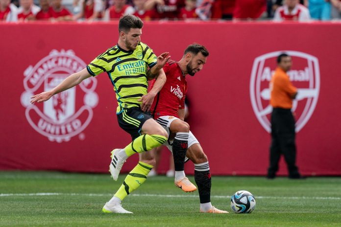 Arsenal midfielder Declan Rice and Manchester United captain Bruno Fernandes fight for the ball during an friendly game.